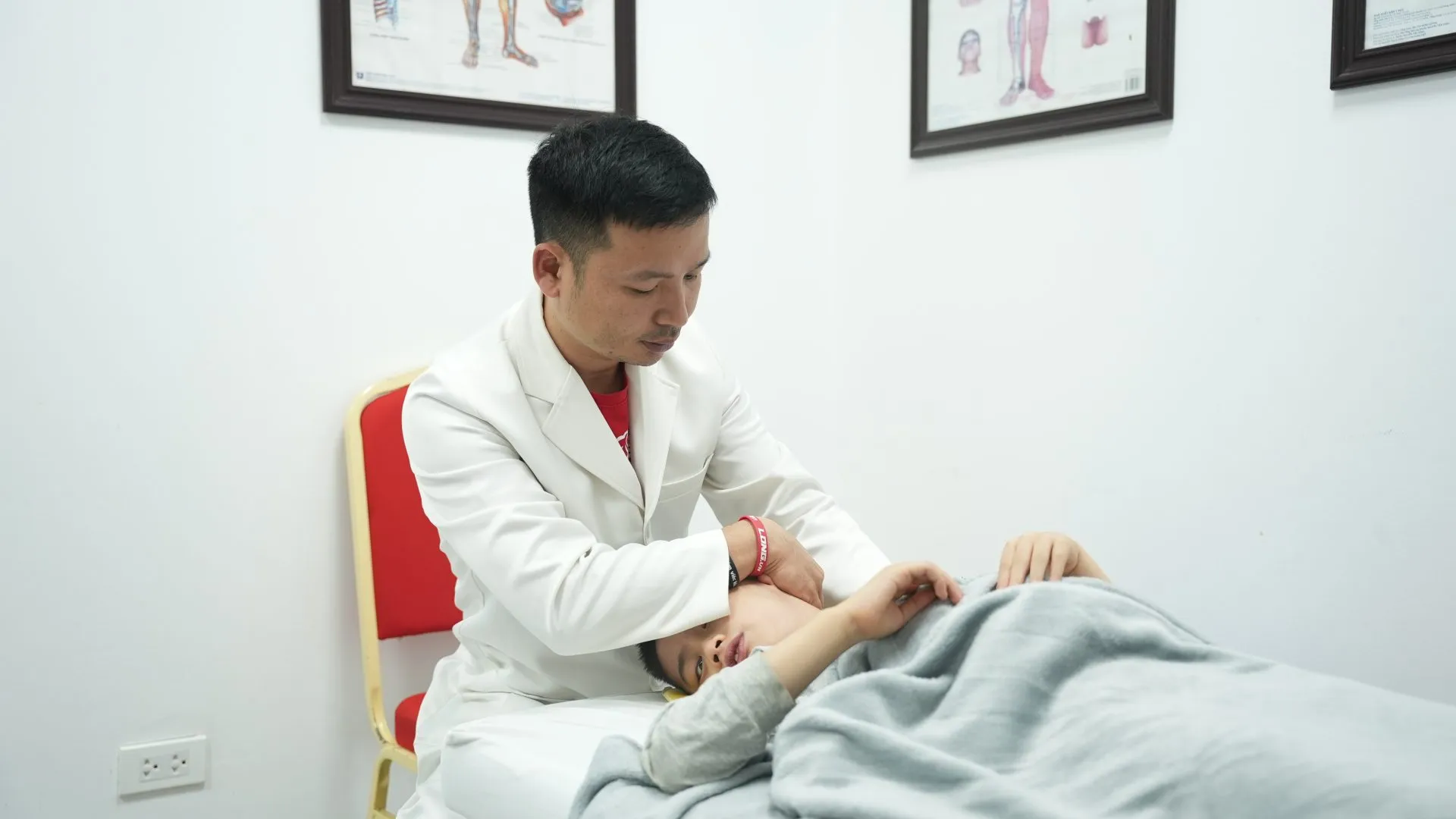 Bác sĩ Nguyễn Quang Hòa vận động cột sống cổ cho Minh Phước